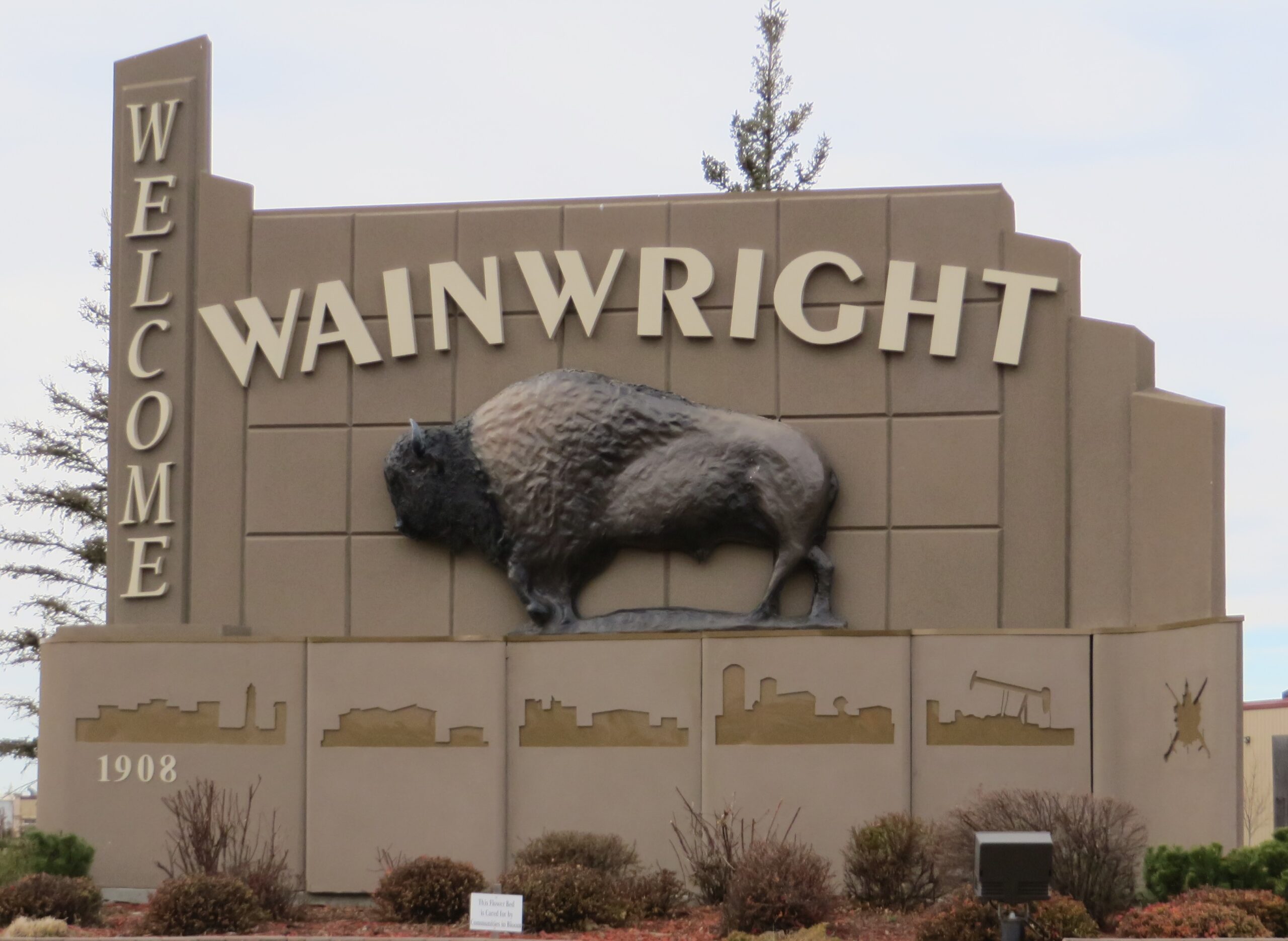 Welcome to Wainwright, Alberta sign featuring a large bison sculpture and the town's founding year, 1908.
